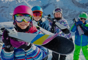 Kinder am Berg beim Ski tragen