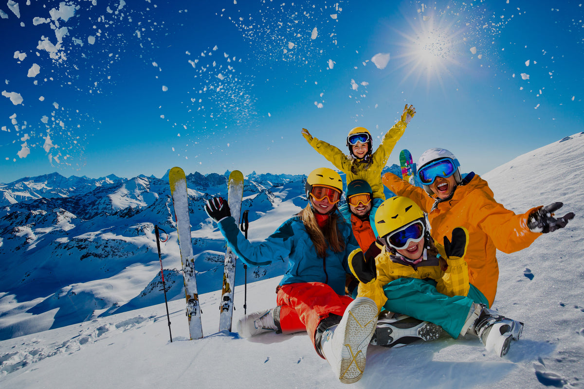 Eine glückliche Familie im Schnee - alle freuen sich auf die reservierten Skiausrüstungen von Sport Edinger in Söll am Wilden Kaiser